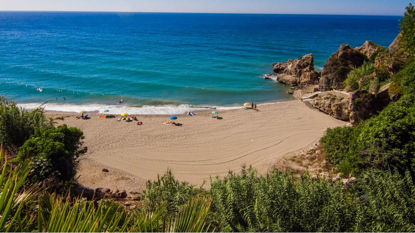La playa que se accede por unos serpenteantes escalones con una de las aguas más turquesas de Málaga